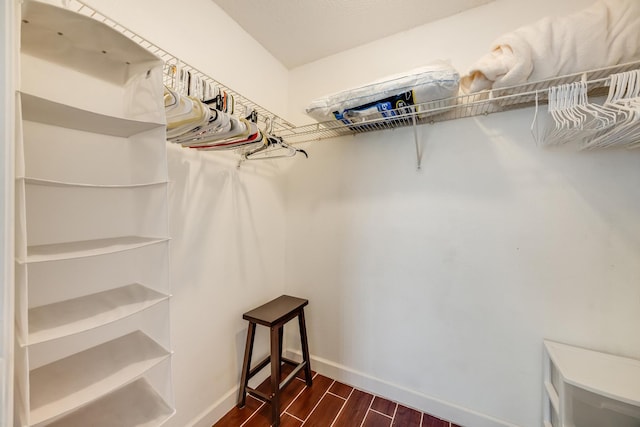 spacious closet with dark wood finished floors