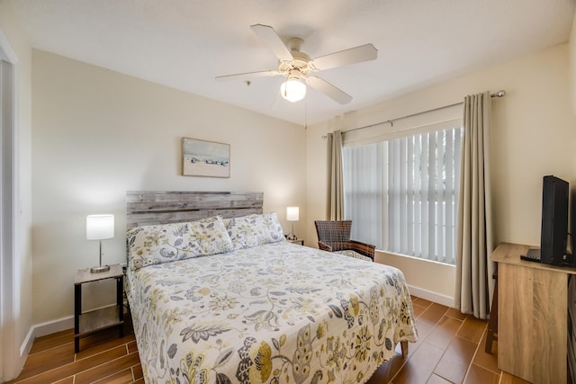 bedroom featuring baseboards, a ceiling fan, and wood tiled floor