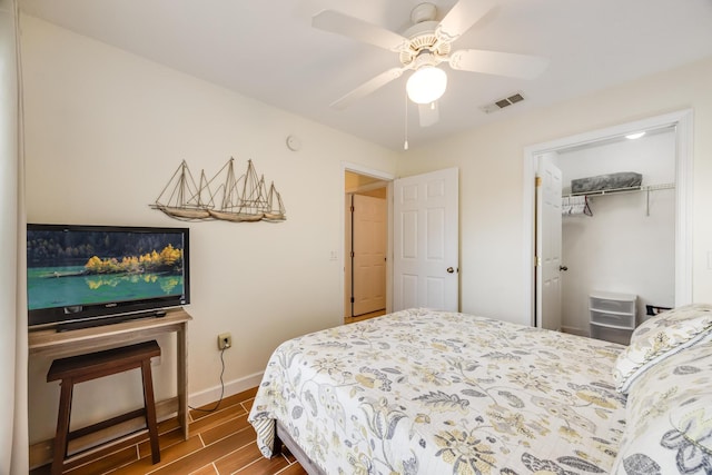 bedroom with wood finish floors, visible vents, a ceiling fan, a closet, and baseboards