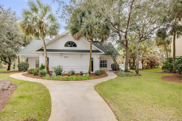 view of front of home featuring stucco siding, driveway, and a front yard