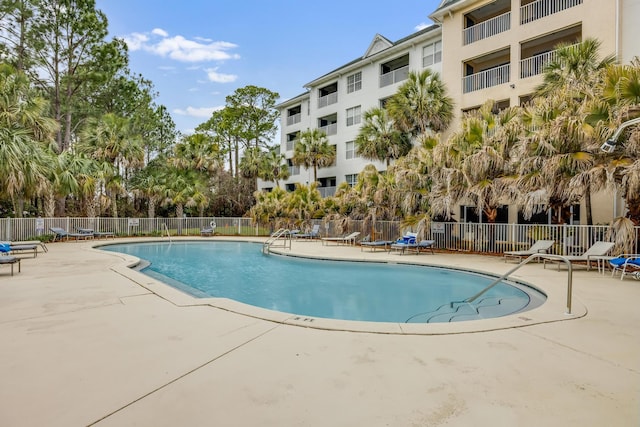 pool with a patio and fence