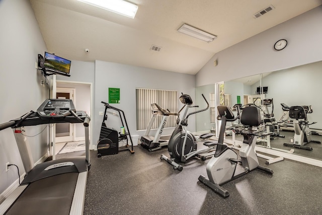 gym with visible vents, lofted ceiling, and baseboards