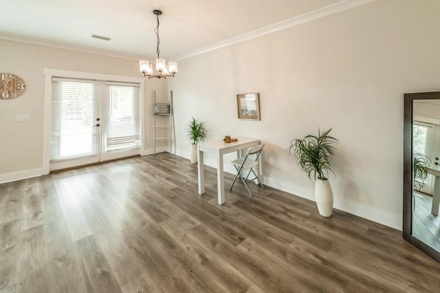 unfurnished dining area featuring an inviting chandelier, wood finished floors, baseboards, and ornamental molding