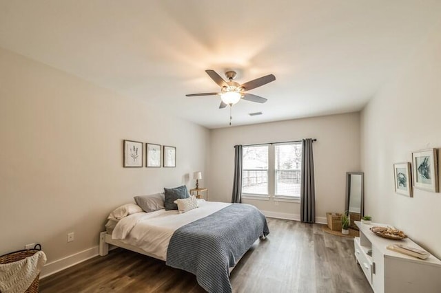 bedroom featuring dark wood finished floors, a ceiling fan, and baseboards