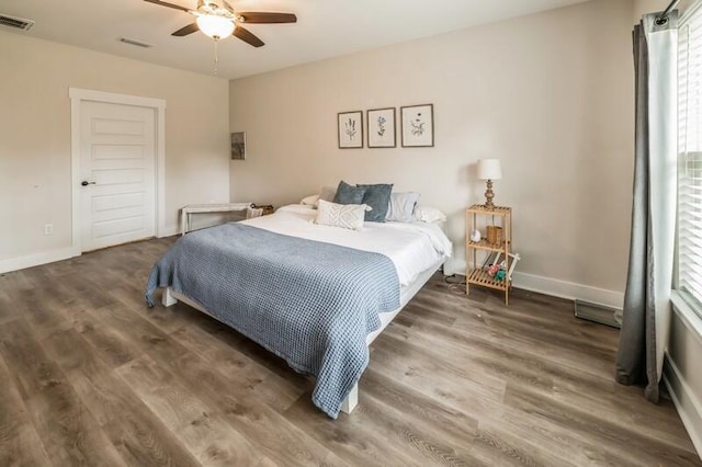 bedroom featuring visible vents, baseboards, and wood finished floors