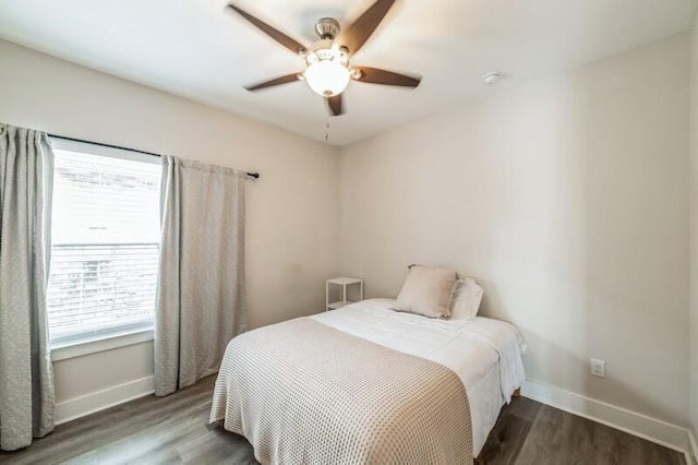 bedroom with a ceiling fan, baseboards, and wood finished floors