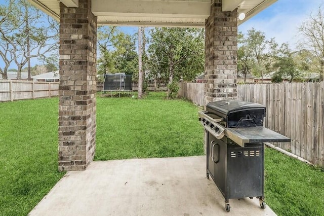 view of yard featuring a patio, a trampoline, and a fenced backyard