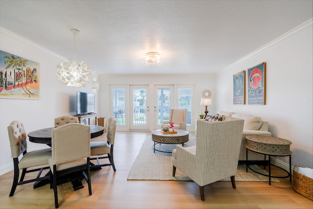 dining space featuring wood finished floors, baseboards, an inviting chandelier, ornamental molding, and a textured ceiling