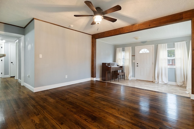 interior space with plenty of natural light, crown molding, baseboards, and wood finished floors