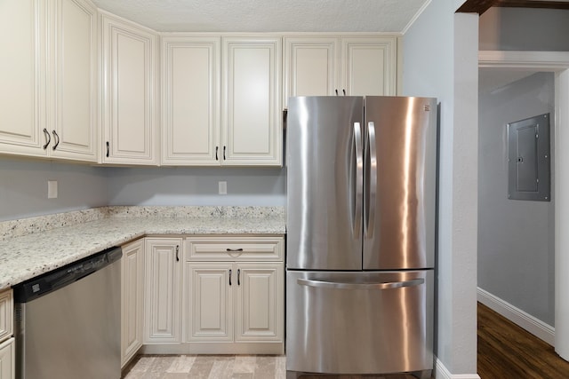 kitchen featuring baseboards, light stone countertops, light wood-type flooring, electric panel, and appliances with stainless steel finishes