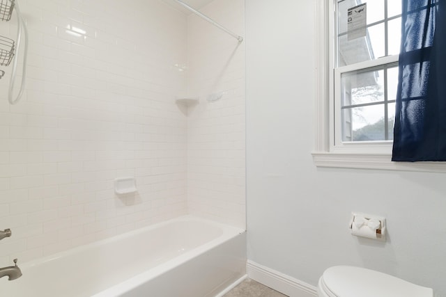 full bath with bathtub / shower combination, toilet, and baseboards