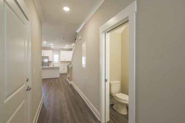 corridor with crown molding, recessed lighting, baseboards, and dark wood-style flooring