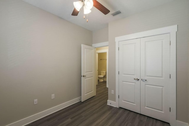 unfurnished bedroom featuring a ceiling fan, visible vents, baseboards, dark wood-type flooring, and a closet