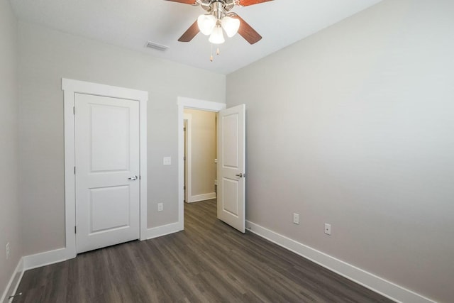 unfurnished bedroom featuring dark wood finished floors, visible vents, ceiling fan, and baseboards