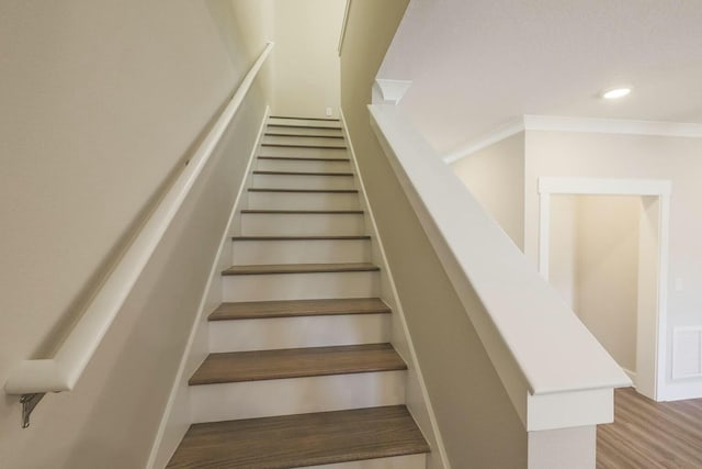 staircase featuring crown molding, wood finished floors, recessed lighting, and visible vents