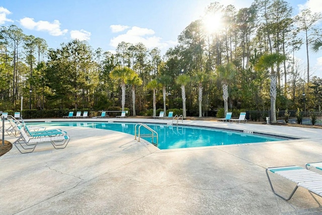 pool with a patio and fence