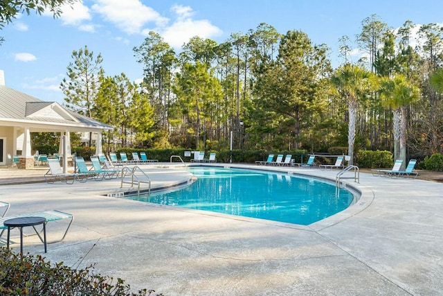 pool with a patio area and fence