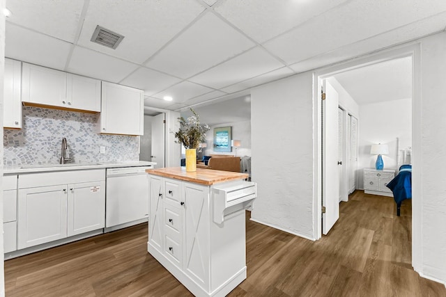 kitchen featuring visible vents, dishwasher, dark wood-type flooring, and a sink