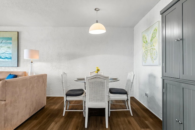 dining space with wood finished floors and a textured wall