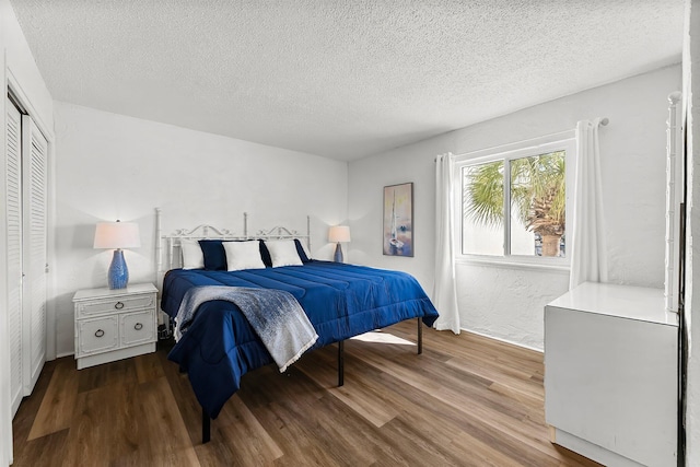 bedroom featuring wood finished floors, a closet, and a textured ceiling