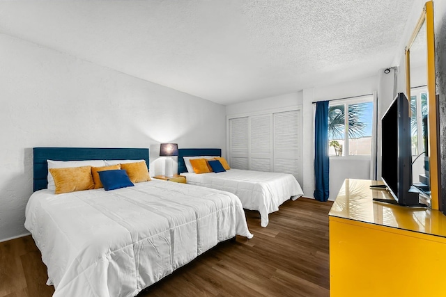 bedroom with a closet, a textured ceiling, and wood finished floors