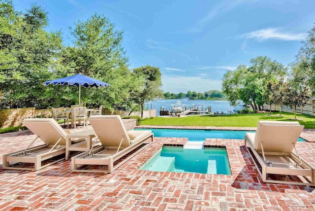 view of pool with fence, a lawn, a patio, outdoor dining space, and a water view