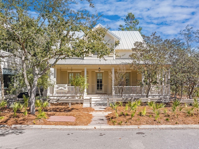 view of front facade with metal roof, a porch, and a standing seam roof