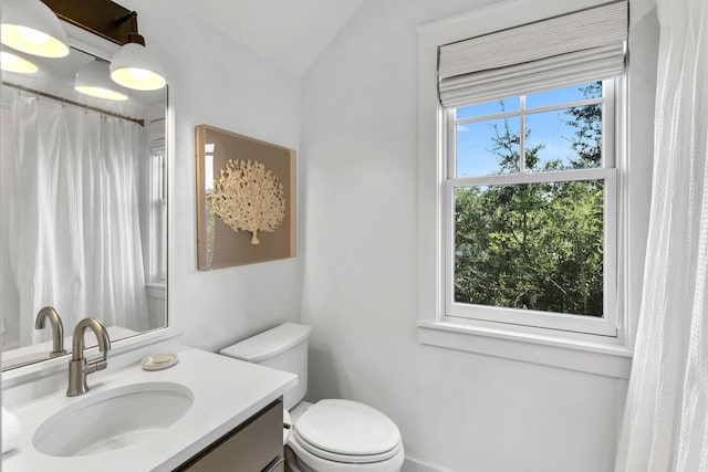 full bath featuring a shower with shower curtain, toilet, and vanity