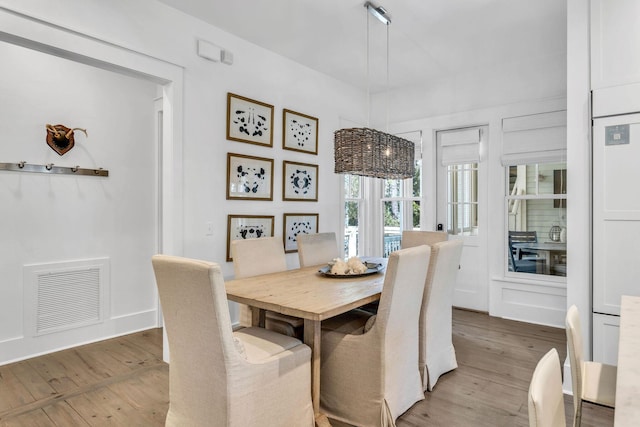 dining space with visible vents and wood finished floors