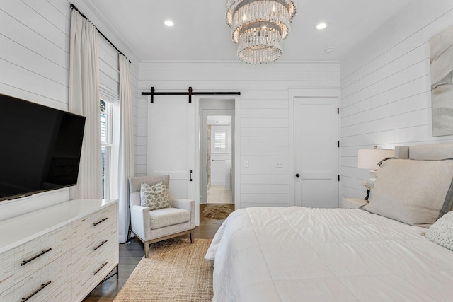 bedroom featuring dark wood finished floors, a chandelier, recessed lighting, and a barn door