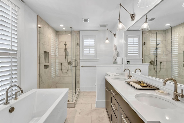 bathroom featuring visible vents, a shower stall, a freestanding bath, and a sink