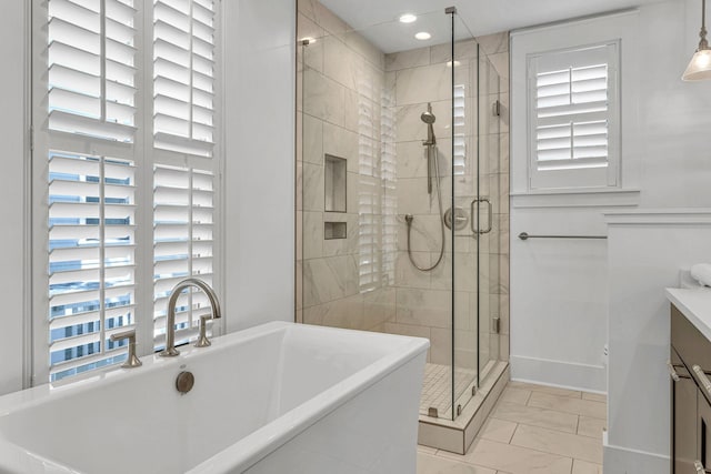 full bath featuring vanity, a freestanding tub, recessed lighting, a shower stall, and marble finish floor