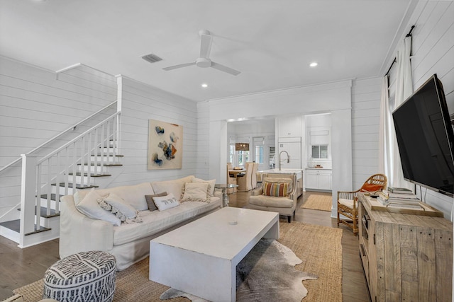 living room featuring wood finished floors, visible vents, recessed lighting, ceiling fan, and stairs