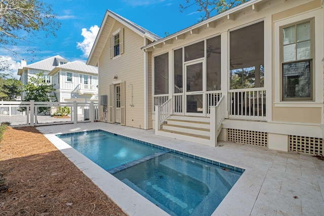 view of pool with a pool with connected hot tub, fence, entry steps, a sunroom, and a patio