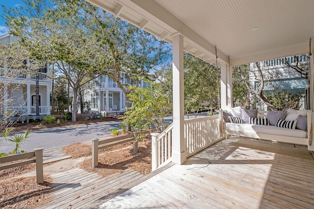 wooden terrace featuring a porch and outdoor lounge area