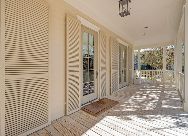 wooden deck with a porch and french doors