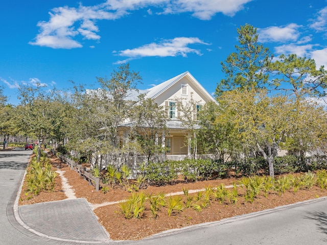 view of property hidden behind natural elements featuring decorative driveway