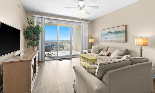 living area featuring visible vents, a ceiling fan, and light wood-style floors