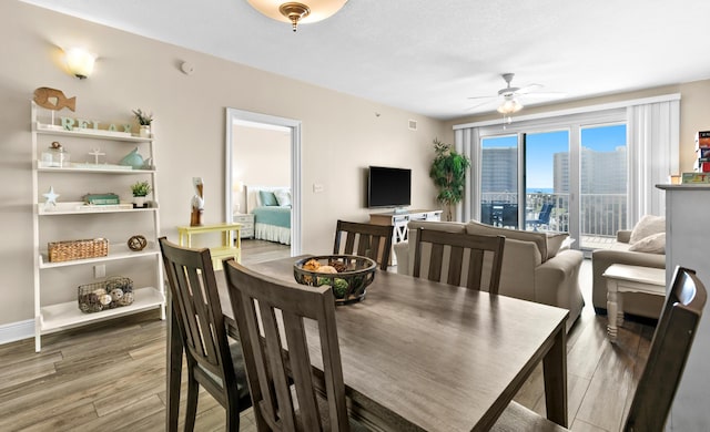 dining room with ceiling fan, baseboards, and wood finished floors