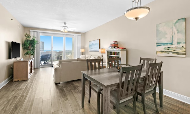 dining room with ceiling fan, baseboards, and wood finished floors