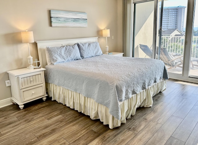 bedroom with access to exterior, dark wood-style floors, and baseboards