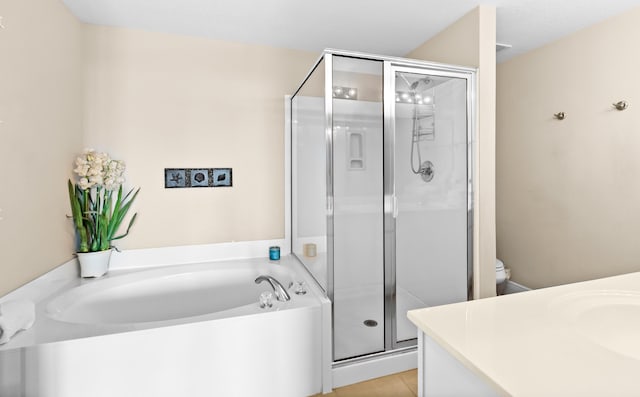 bathroom featuring tile patterned floors, vanity, a bath, and a shower stall