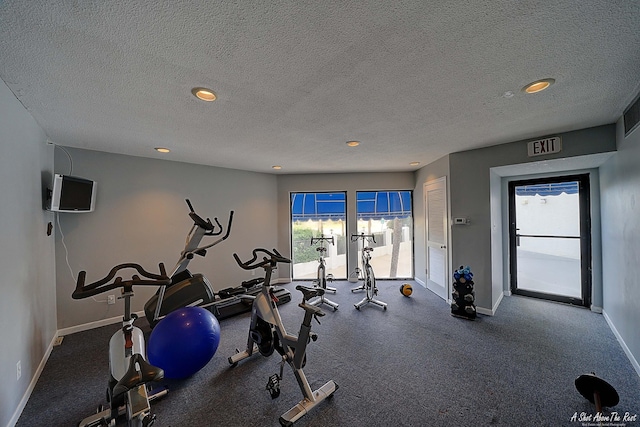 workout area with visible vents, baseboards, and a textured ceiling