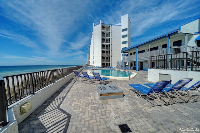 community pool featuring a patio and a water view