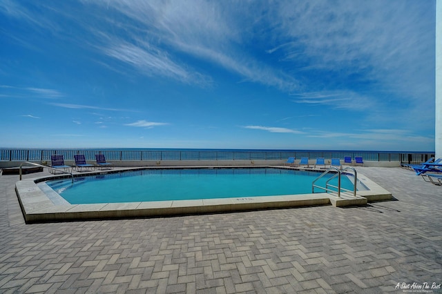 pool with a patio and a water view