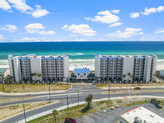 birds eye view of property with a water view and a beach view