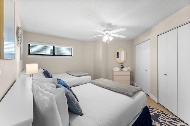 bedroom with multiple closets and ceiling fan