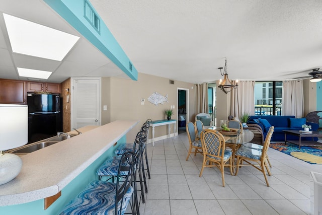 dining space featuring light tile patterned floors, visible vents, a textured ceiling, and a ceiling fan