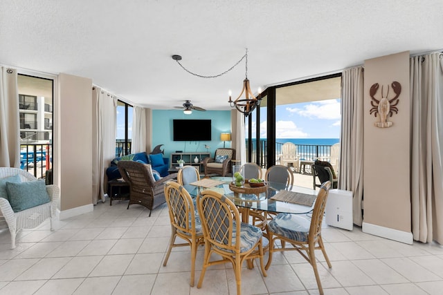 dining space with a wall of windows, a wealth of natural light, a textured ceiling, and light tile patterned flooring