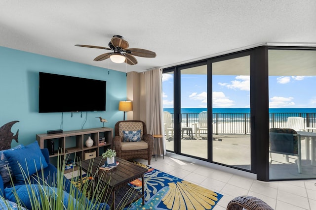 tiled living room featuring a textured ceiling, a wall of windows, and ceiling fan